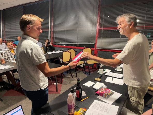 Henrik krijgt uit handen van Ted een presentje voor zijn benoeming - Herman Zonderland
